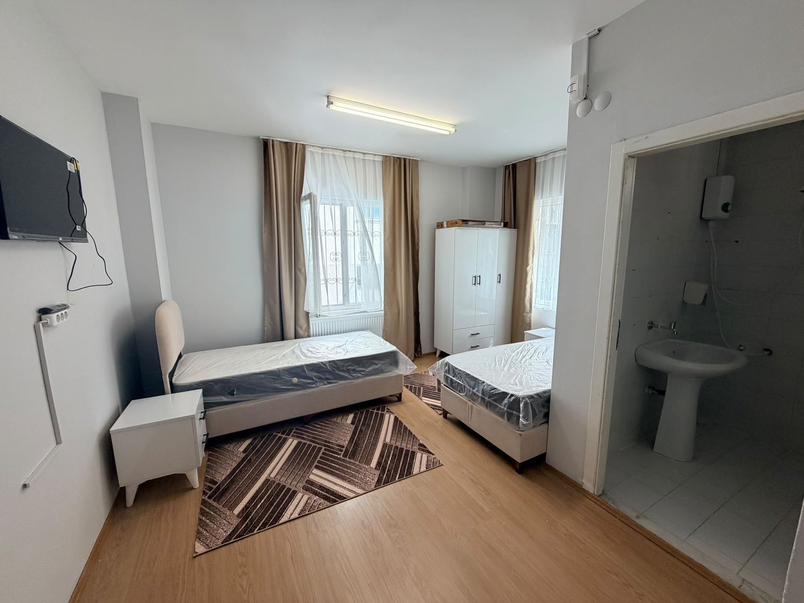 A double room with two beds, a television and its own bathroom